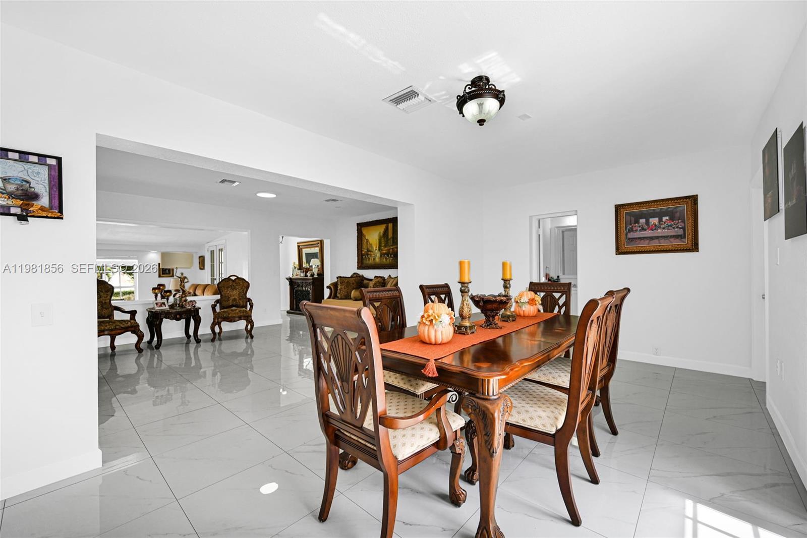 756 West 53rd Street Hialeah, FL 33012 - Photo 14 of 65 a view of a dining room and livingroom with furniture a rug a painting and a chandelier