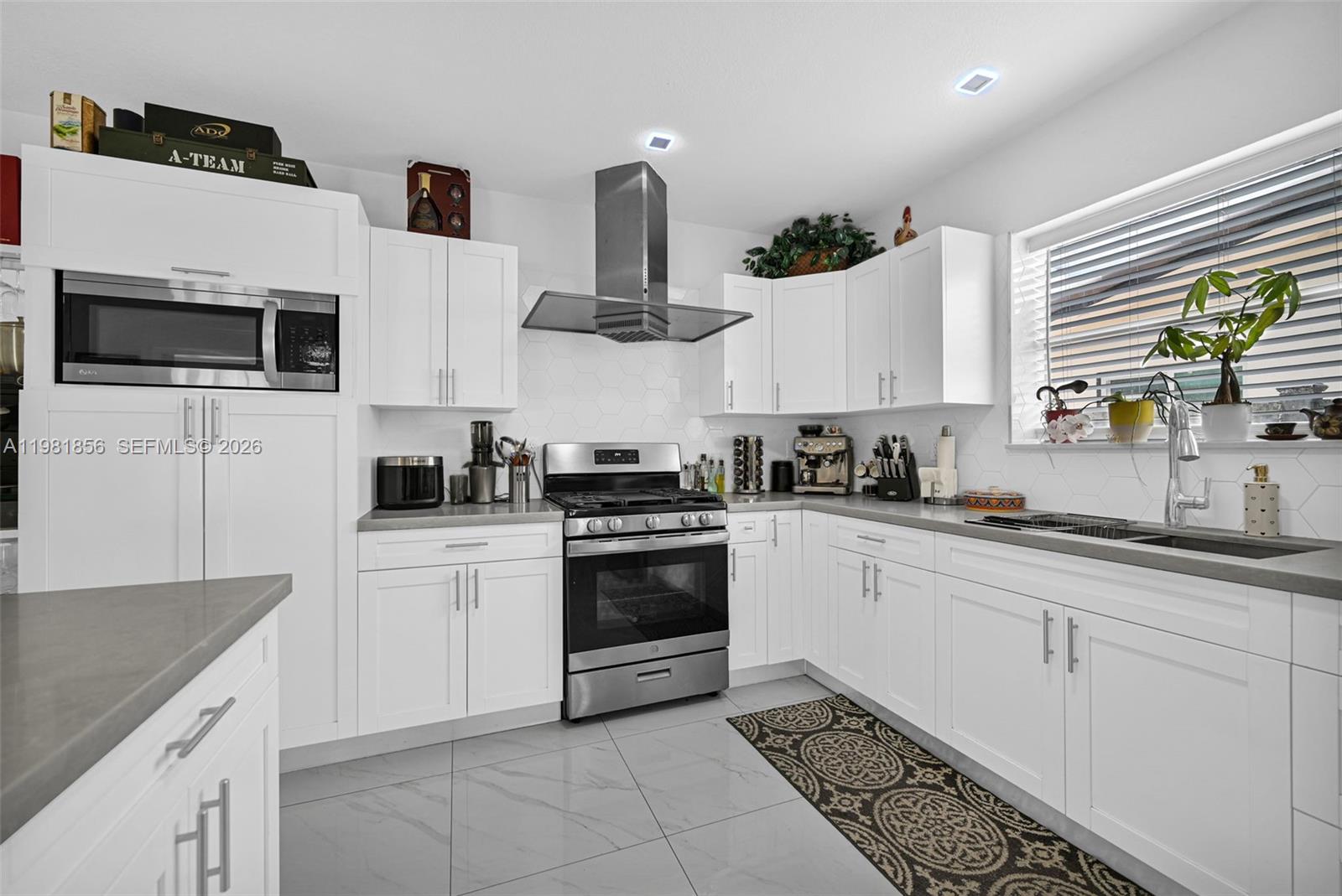 756 West 53rd Street Hialeah, FL 33012 - Photo 18 of 65 a kitchen with stainless steel appliances white cabinets a sink and a stove