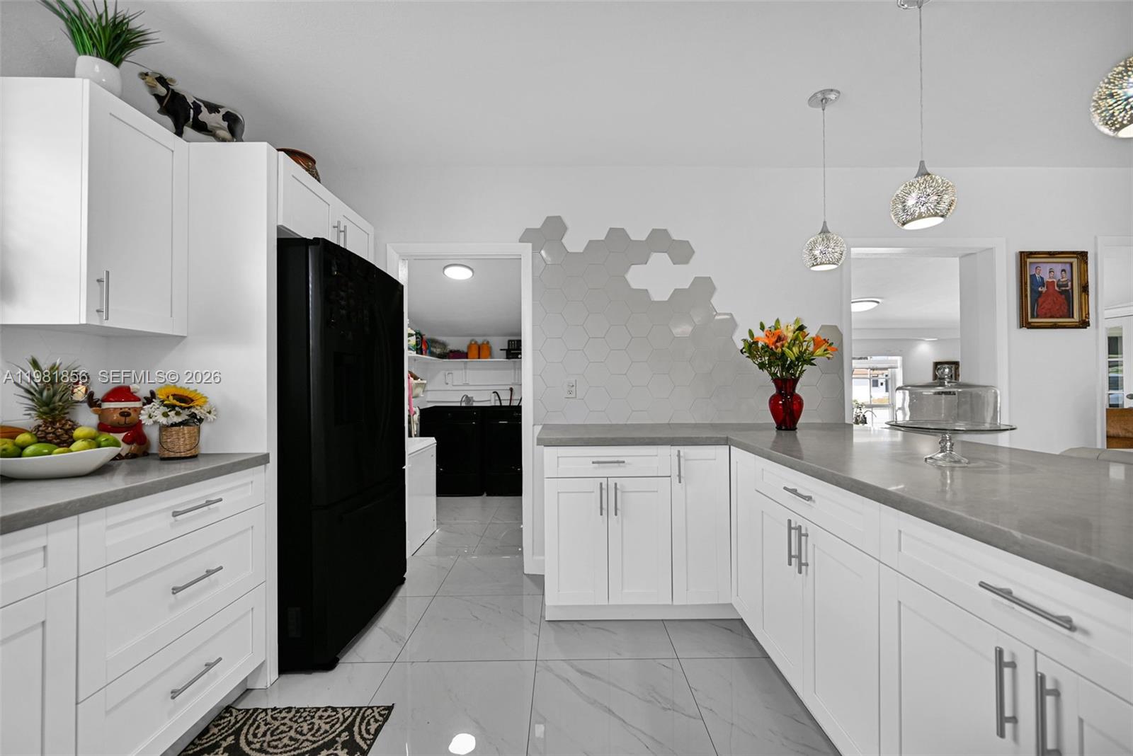 756 West 53rd Street Hialeah, FL 33012 - Photo 20 of 65 a kitchen with kitchen island granite countertop white cabinets and refrigerator
