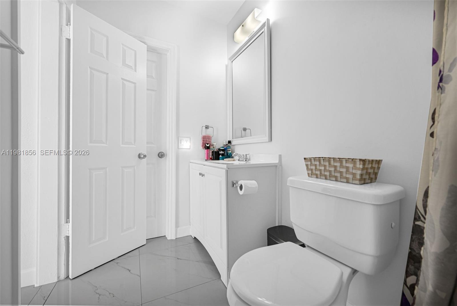 756 West 53rd Street Hialeah, FL 33012 - Photo 42 of 65 a bathroom with a toilet a sink and a mirror