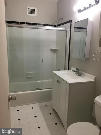 a bathroom with a sink mirror vanity and toilet