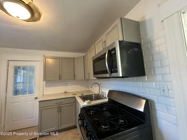 a kitchen with a stove a sink and a microwave