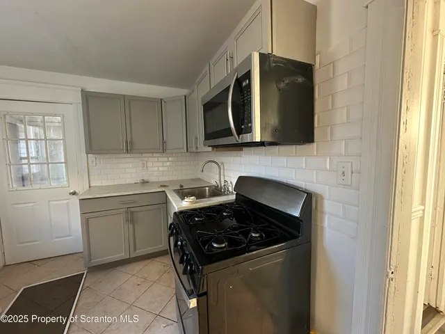 a kitchen with a sink stove and microwave