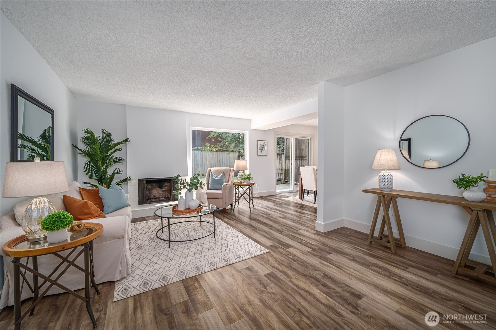 a living room with furniture a potted plant and a large window