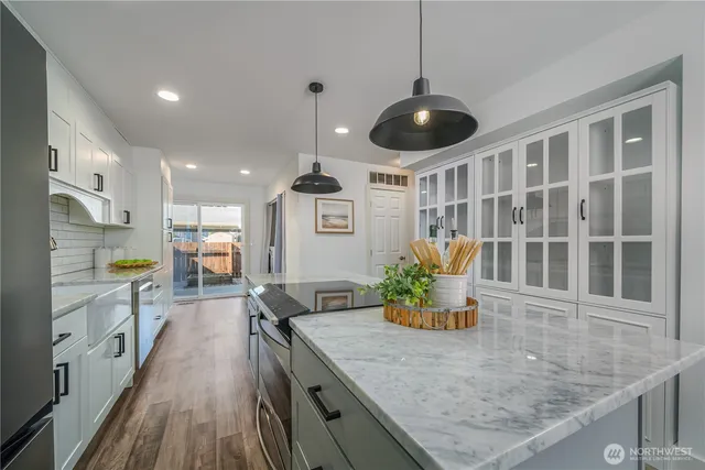 a kitchen with stainless steel appliances granite countertop a stove and a wooden floors