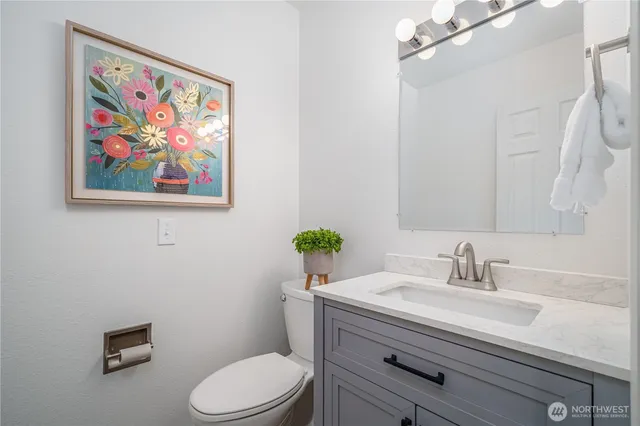 a bathroom with a toilet a sink and mirror