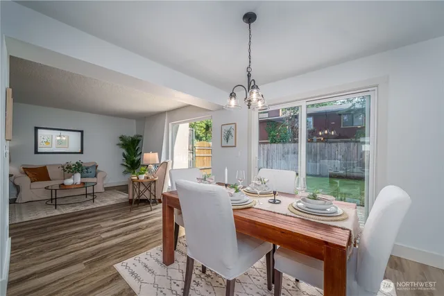 a dining room with furniture a chandelier and wooden floor
