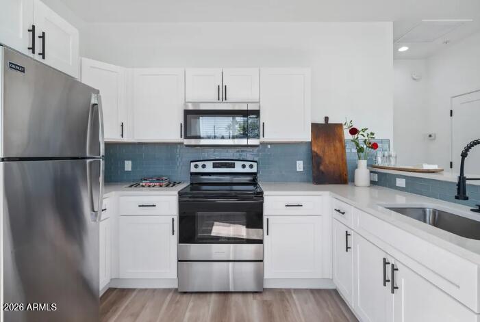 4202 North 10th Street, Unit 3 Phoenix, AZ 85014 - Photo 7 of 11 a kitchen with white cabinets and stainless steel appliances