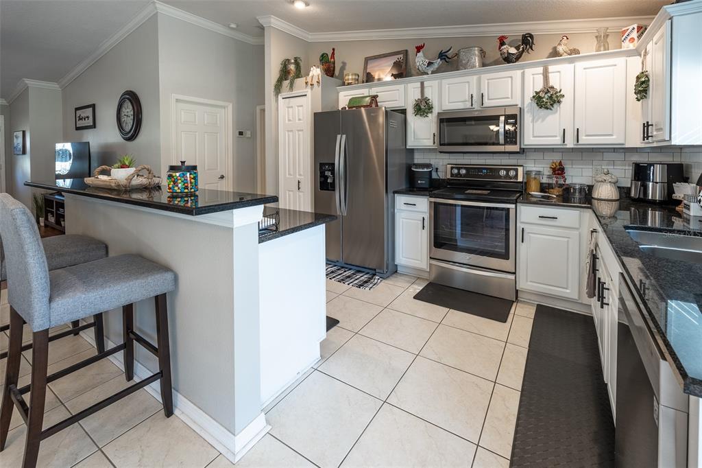 15143 Southwest 14th Avenue Road Ocala, FL 34473 - Photo 11 of 53 a kitchen with stainless steel appliances a stove a sink and a refrigerator