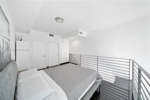a bedroom with a white bed and a chandelier