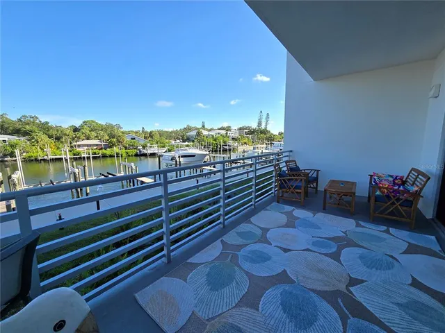 a view of a balcony with chairs and a potted plant