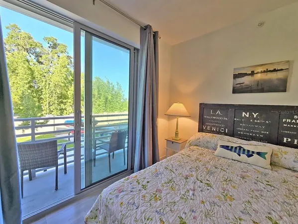 a bedroom with a bed and a dresser next to a window