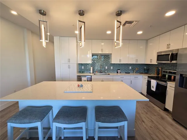 a kitchen with a dining table chairs and refrigerator