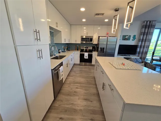 a large white kitchen with stainless steel appliances