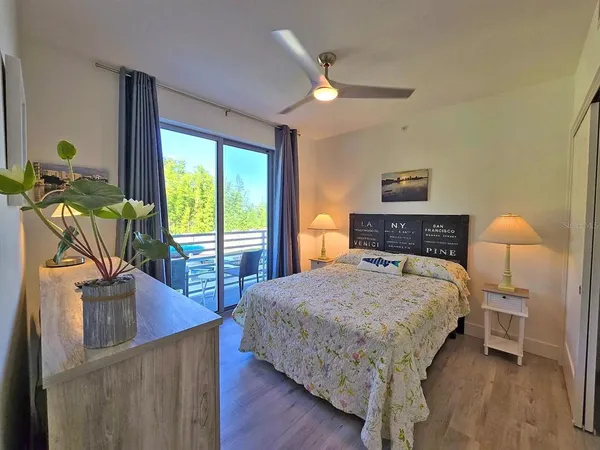 a bedroom with a bed a table and painting on the wall