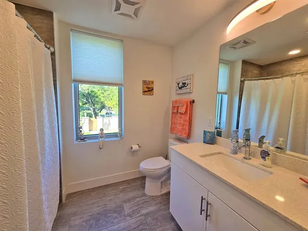a bathroom with a double vanity sink toilet and a mirror
