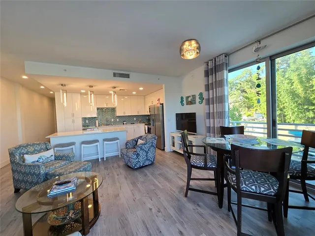 a dining room with furniture and a floor to ceiling window