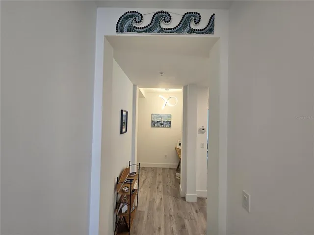 a view of a hallway with wooden floor