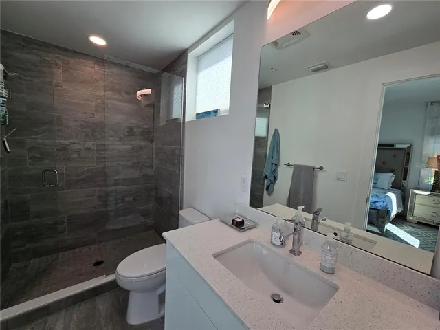 a bathroom with a sink toilet a mirror and shower