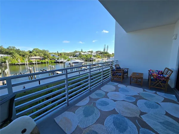 a view of a balcony with chairs and a potted plant