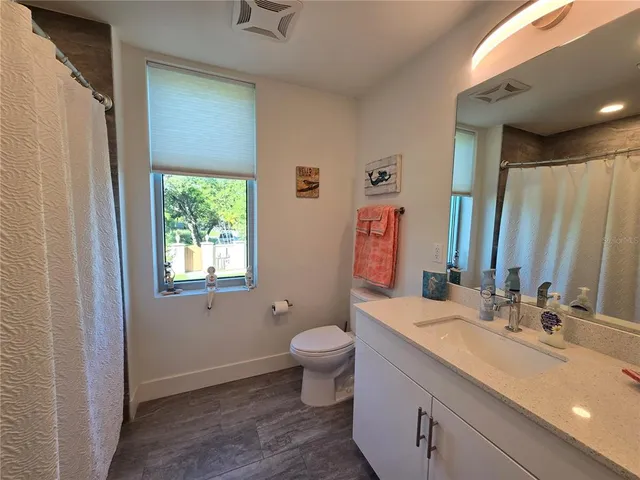a bathroom with a double vanity sink toilet and a mirror