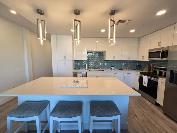 a kitchen with a dining table chairs and refrigerator