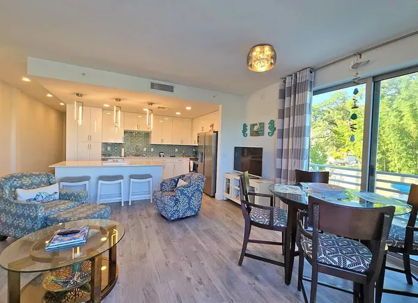 a dining room with furniture and a floor to ceiling window