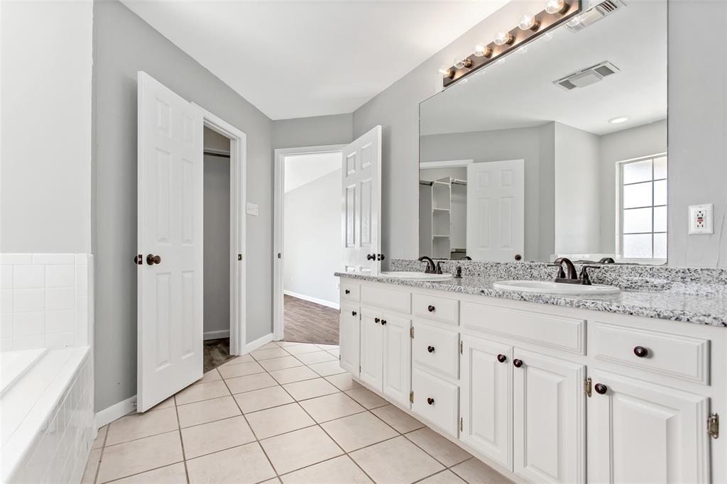 712 Billups Street Van Alstyne, TX 75495 - Photo 24 of 38 a bathroom with a granite countertop sink mirror and a bathtub
