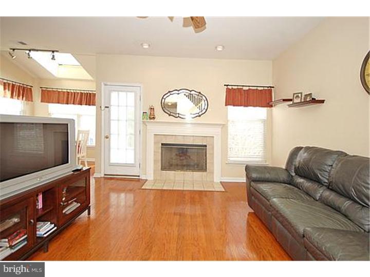 3 Sandstone Road East Windsor, NJ 08520 - Photo 3 of 24 a living room with furniture a flat screen tv and a fireplace