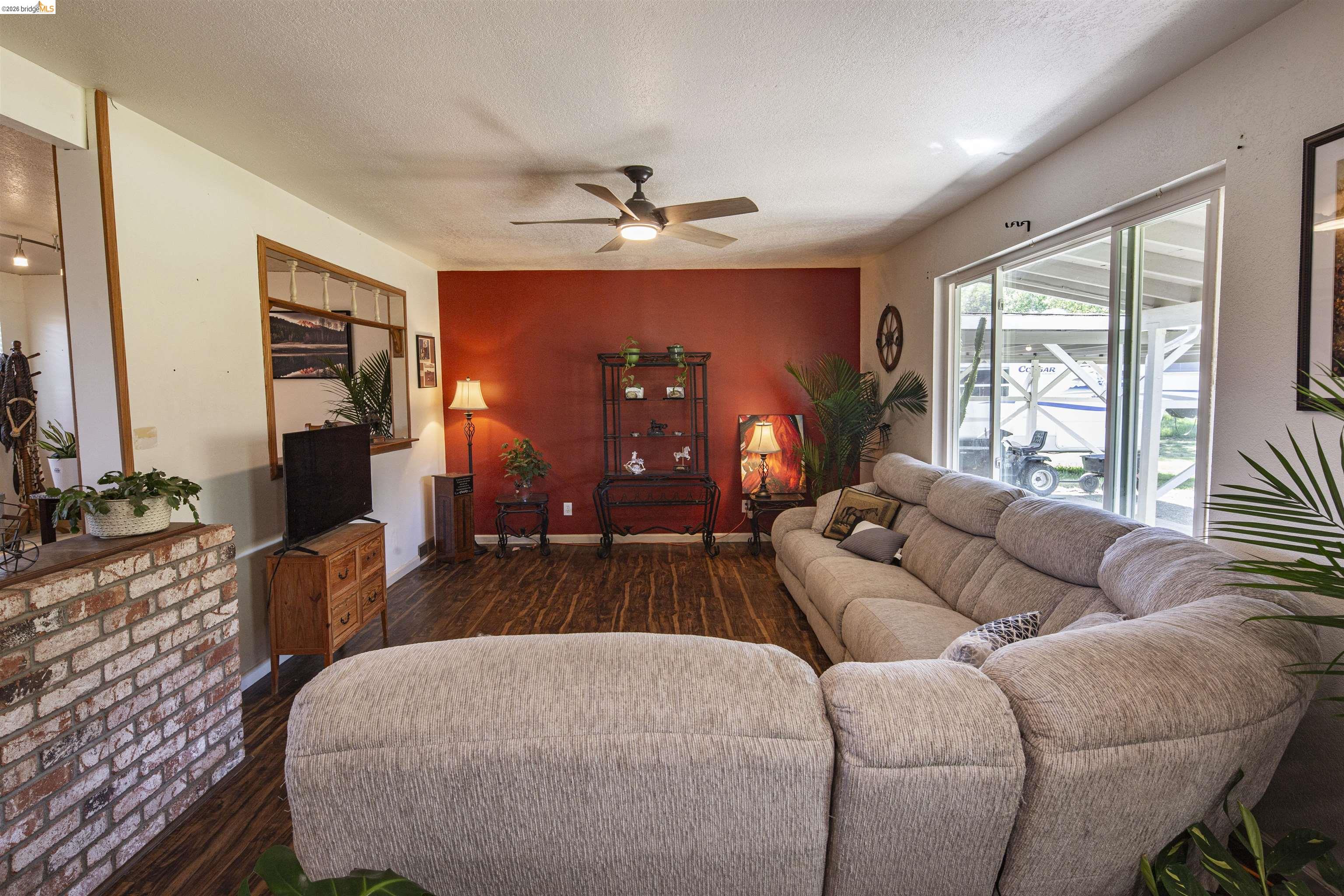 10458 Southworth Road Valley Springs, CA 95252 - Photo 6 of 24 Living room featuring dark wood-type flooring, a ceiling fan, and a textured ceiling