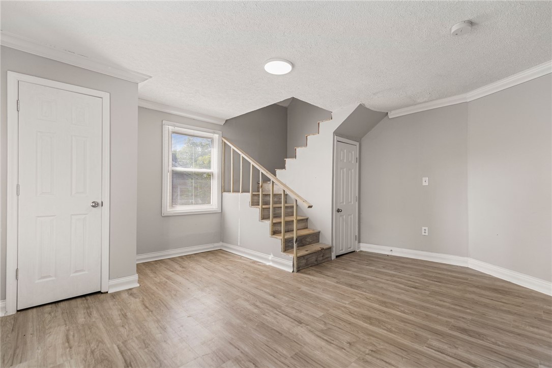 109 Farmer Street Anderson, SC 29621 - Photo 27 of 31 A versatile open space with a wooden staircase and durable flooring, ideal for various living arrangements.