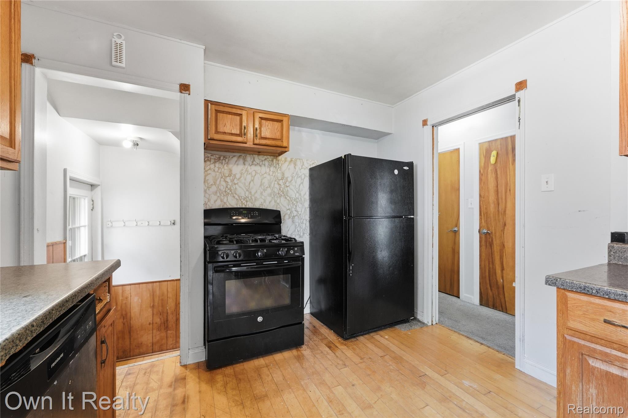 3331 Harding Street Dearborn, MI 48124 - Photo 14 of 31 Kitchen featuring wood-finish flooring, wood cabinetry, a black range, a black refrigerator, and a black dishwasher
