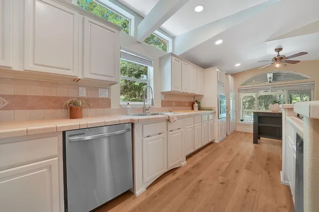 a kitchen with kitchen island granite countertop a sink appliances cabinets and a counter top space