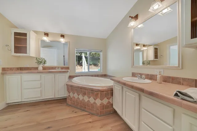 a spacious bathroom with a double vanity sink a mirror and a