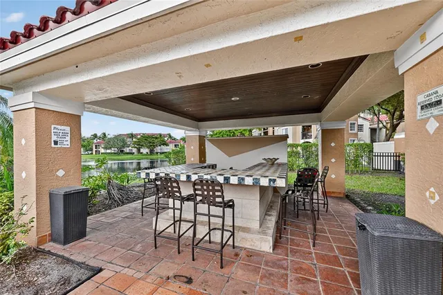 a patio with table and chairs and potted plants