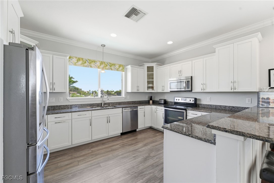 12304 Boat Shell Drive Matlacha Isles, FL 33991 - Photo 20 of 49 a kitchen with granite countertop stainless steel appliances a refrigerator sink and microwave