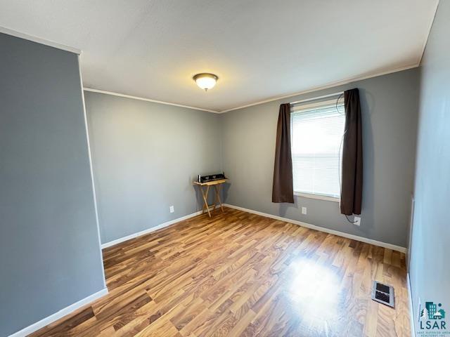 12 West St Louis River Road Esko, MN 55733 - Photo 15 of 20 Spare room with hardwood / wood-style floors and crown molding