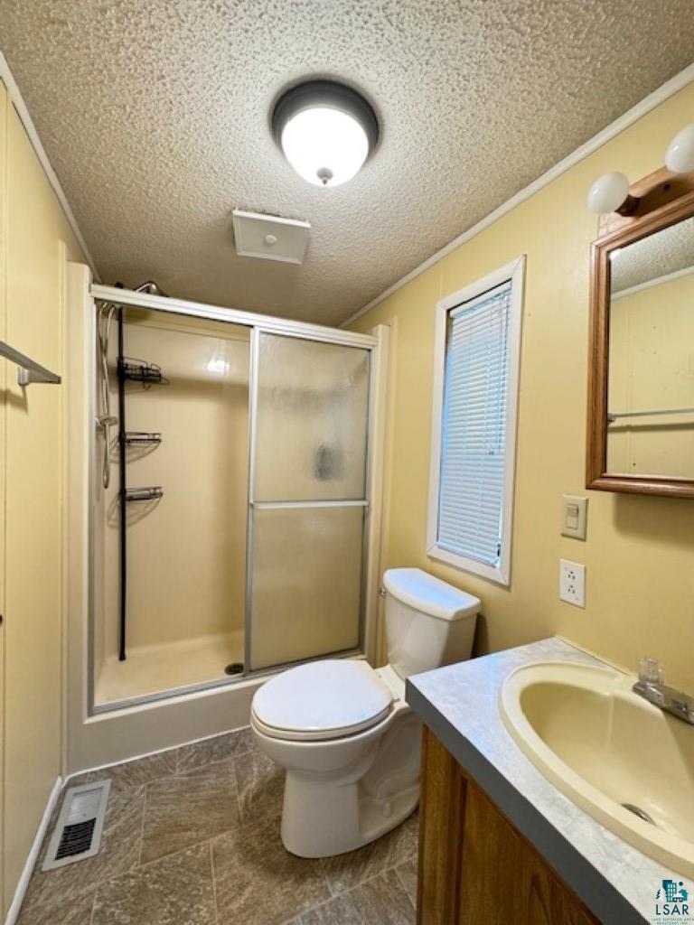 12 West St Louis River Road Esko, MN 55733 - Photo 17 of 20 Bathroom featuring walk in shower, tile flooring, a textured ceiling, vanity, and toilet
