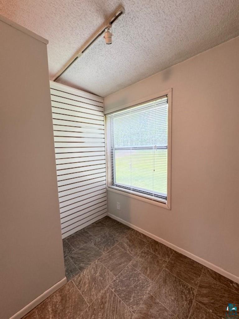 12 West St Louis River Road Esko, MN 55733 - Photo 19 of 20 Spare room with a textured ceiling and dark tile flooring