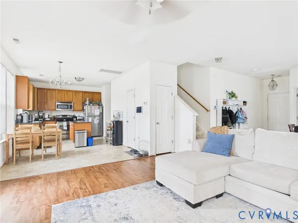 a living room with furniture and a dining table with kitchen view
