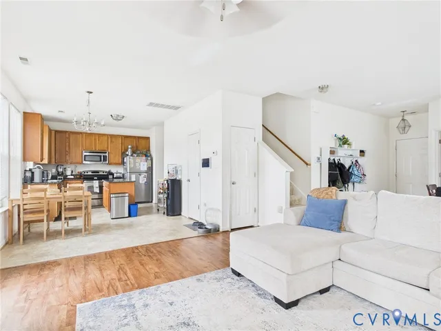 a living room with furniture and a dining table with kitchen view