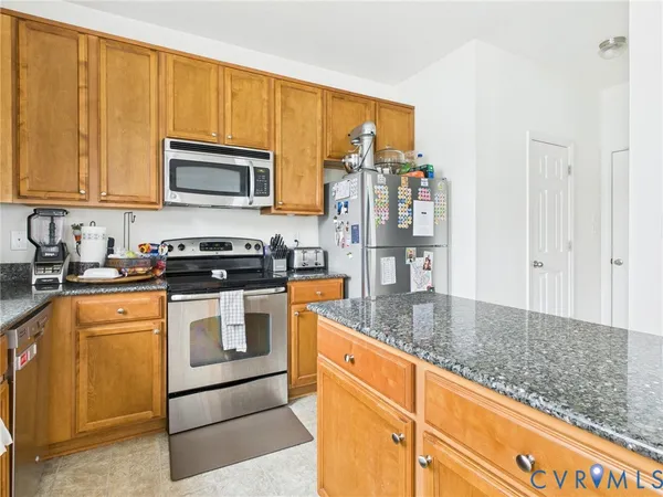 a kitchen with stainless steel appliances granite countertop a sink a stove and cabinets
