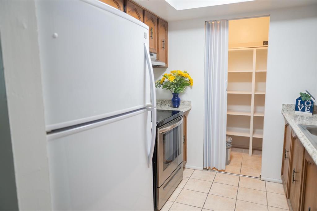 1902 Honour Road, Unit 23 Orlando, FL 32839 - Photo 12 of 31 a kitchen with a refrigerator and cabinets
