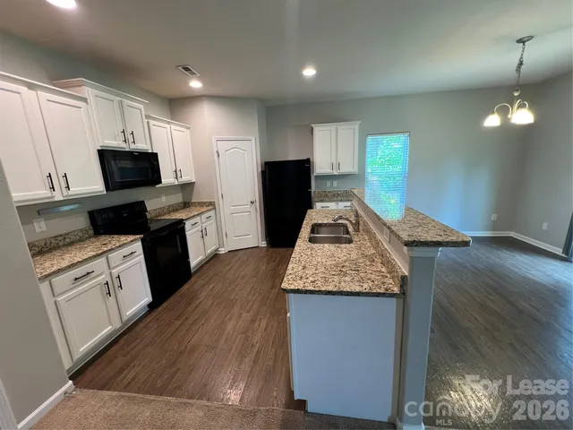a kitchen with sink refrigerator and microwave