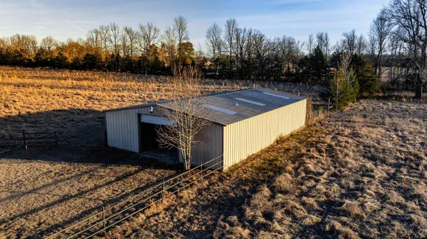a backyard of a house with table and chairs under an umbrella