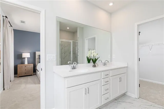 a en suite bathroom with a double vanity sink and mirror