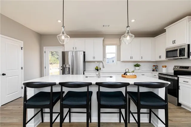 a kitchen with a dining table chairs and cabinets