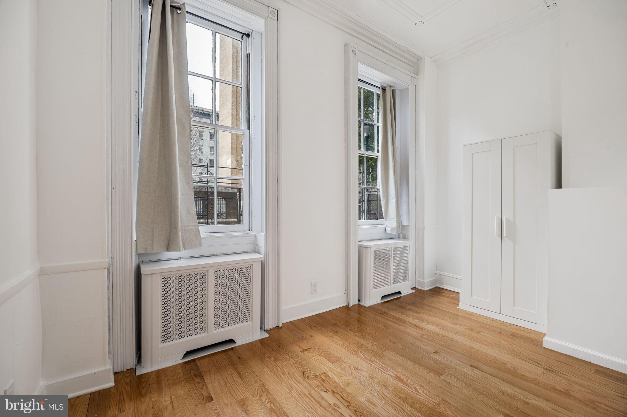 1225 Spruce Street, Unit 1F Philadelphia, PA 19107 - Photo 13 of 21 an empty room with wooden floor and windows