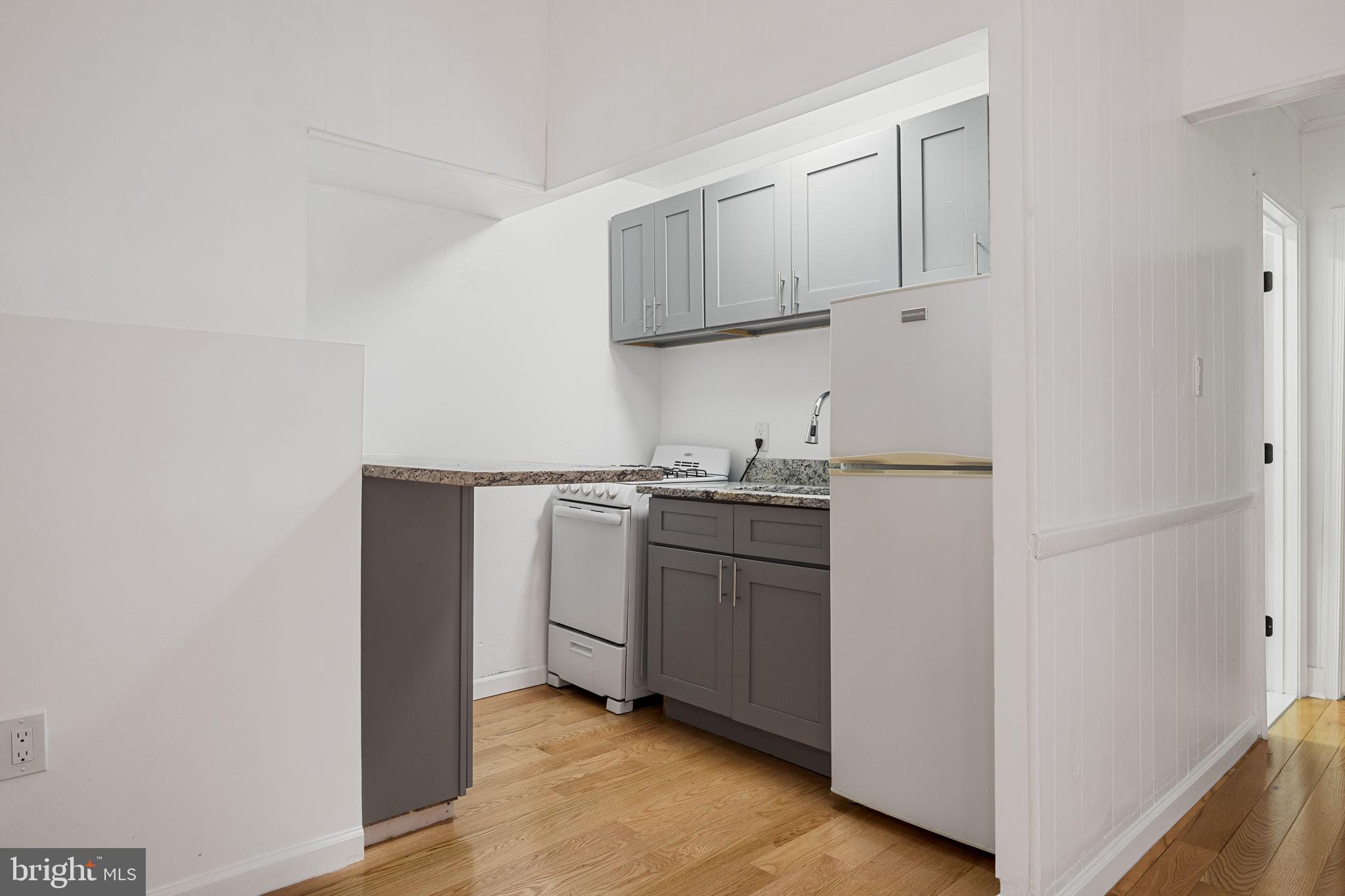 1225 Spruce Street, Unit 1F Philadelphia, PA 19107 - Photo 6 of 21 a kitchen with white cabinets and white appliances