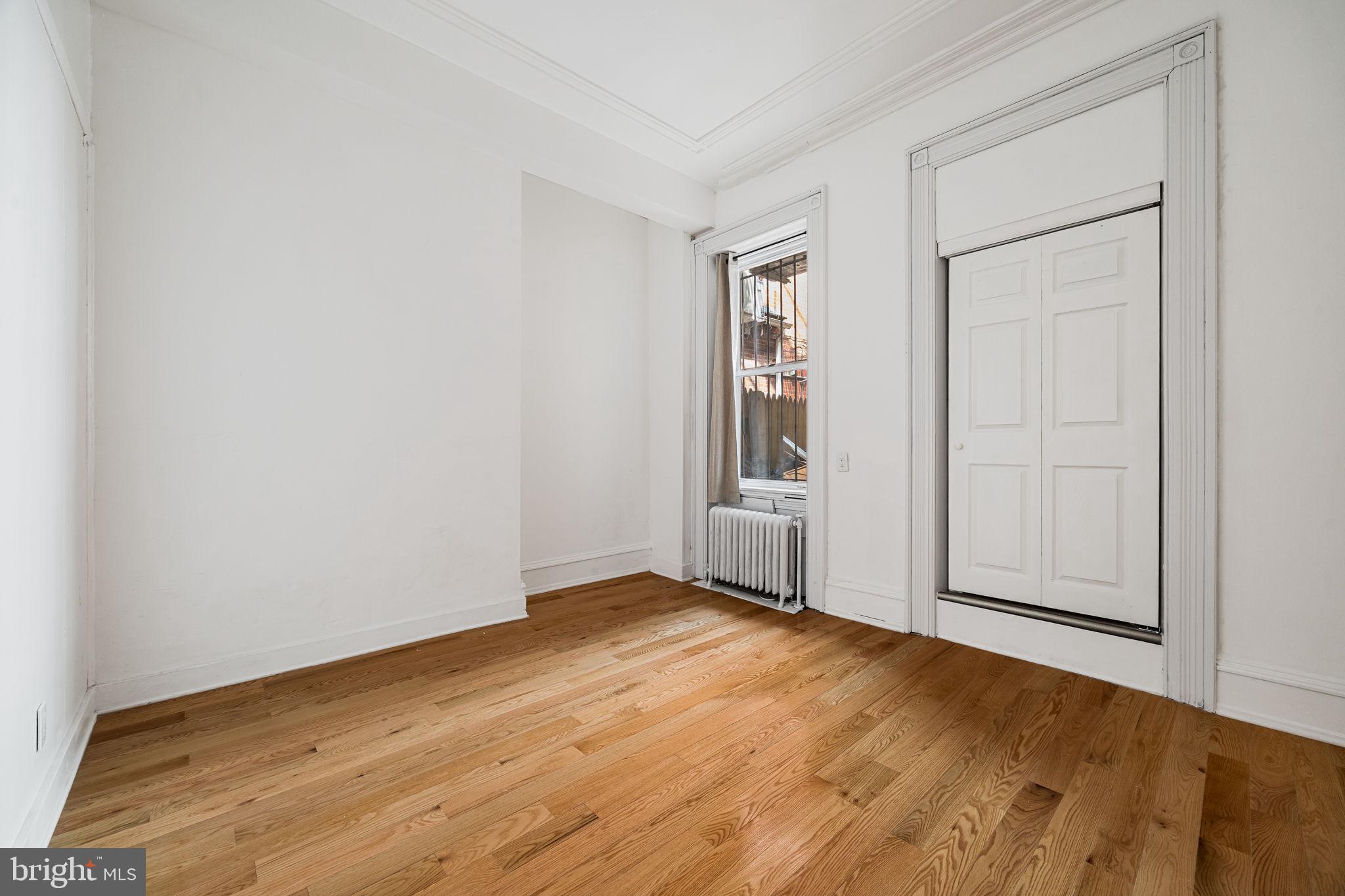 1225 Spruce Street, Unit 1F Philadelphia, PA 19107 - Photo 10 of 21 an empty room with wooden floor and windows